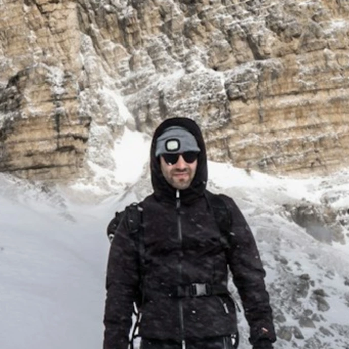 a man standing on top of a snow covered slope